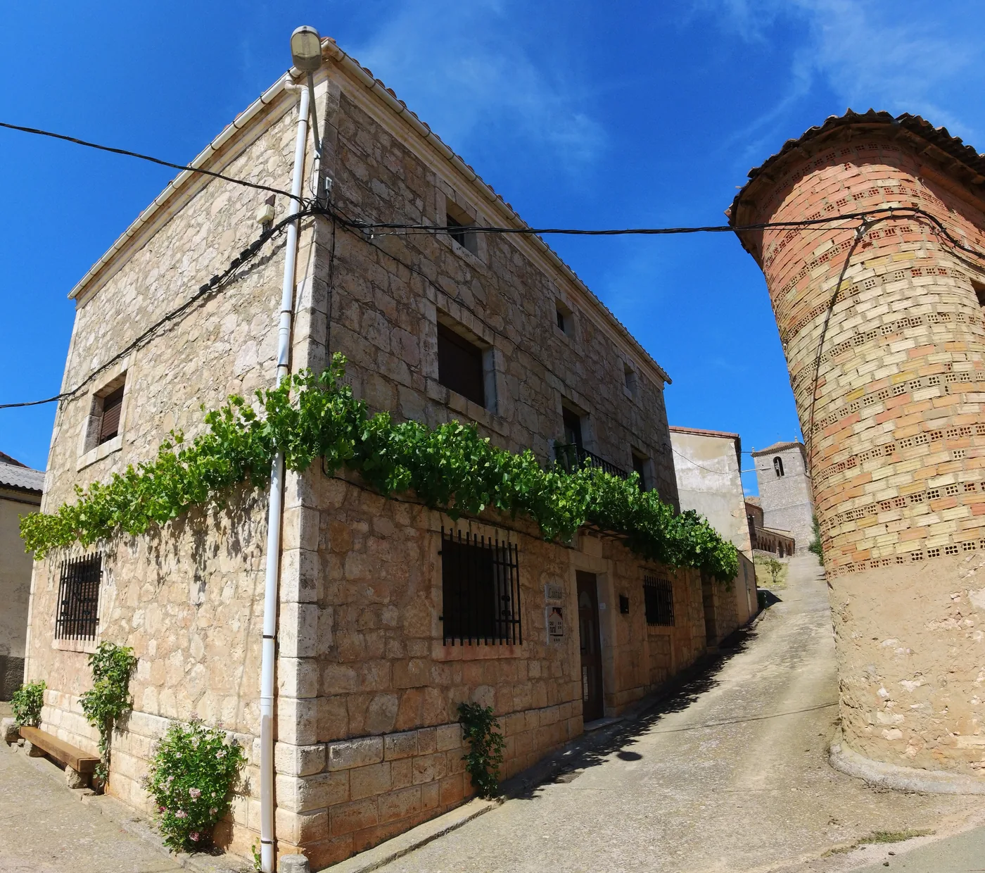 Casa Rural Lutia junto a la torre de la iglesia de San Miguel Arcángel, en Andaluz
