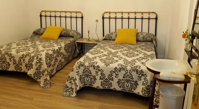 Camas de forja con cojines amarillos