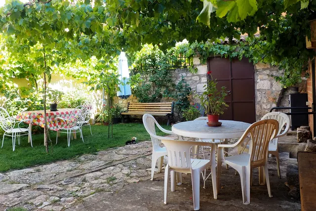 Jardín con mesa bajo la parra
